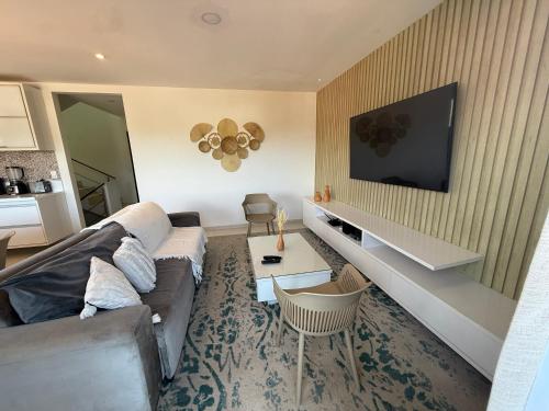 a living room with a couch and a tv at Casa Ribeiro Morro de São Paulo in Morro de São Paulo