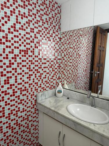 a bathroom with a sink and a red and white tiled wall at Casa Ribeiro Morro de São Paulo in Morro de São Paulo