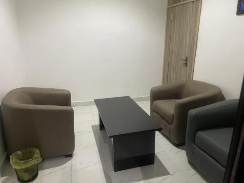 a living room with two chairs and a table at Murphy's Mansion Resort in Umuahia