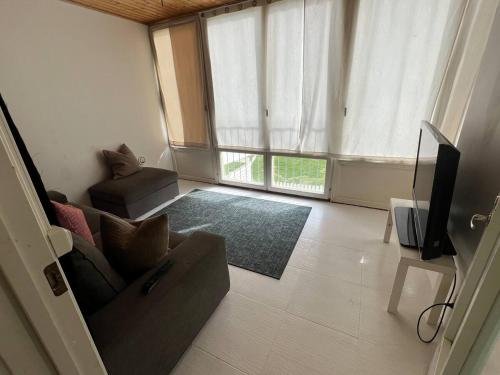 a living room with a couch and a television at 5 beds apartment in Västerås