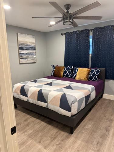 a bedroom with a bed with a ceiling fan at Quirky Museum District Apartment in Prime Location in Houston