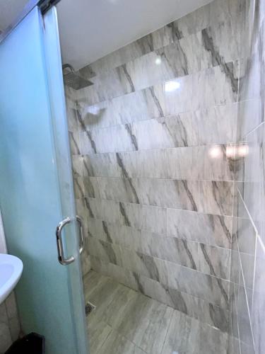a bathroom with a shower with a stone wall at Hi pyramids view in Banī Ghālib