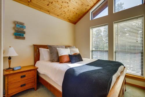 a bedroom with a bed with a nightstand and a window at Mtn-View Deck: Cabin Getaway in Angel Fire in Angel Fire
