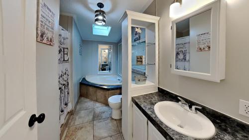 a bathroom with a sink and a toilet and a tub at Island Club #27 in Put-in-Bay