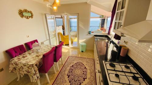 a kitchen and dining room with a table and purple chairs at White Pearl in Trabzon