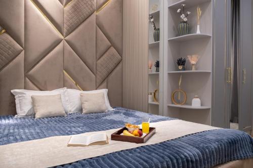 a bedroom with a bed with a tray of fruit on it at Nest One Luxe, Элитные апартаменты с террасой и панорамным видом in Tashkent