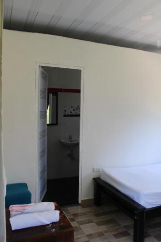 a bedroom with a bed and a bathroom with a sink at Posada Campestre brisas del camino in Puerto Triunfo