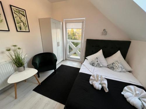 a bedroom with a bed and a chair and a window at Gościniec przy Spacerowej in Długołęka