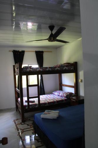 a bedroom with two bunk beds and a ceiling fan at Posada Campestre brisas del camino in Puerto Triunfo