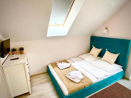a small bedroom with a bed with a blue headboard at Gościniec przy Spacerowej in Długołęka