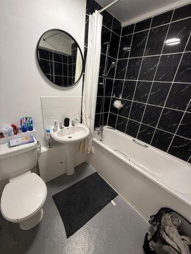 a bathroom with a toilet and a sink and a bath tub at Private Room with King Size Bed, TV and Shared Bathroom in London