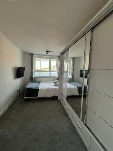 a bedroom with two beds and a mirror at Private Room with King Size Bed, TV and Shared Bathroom in London