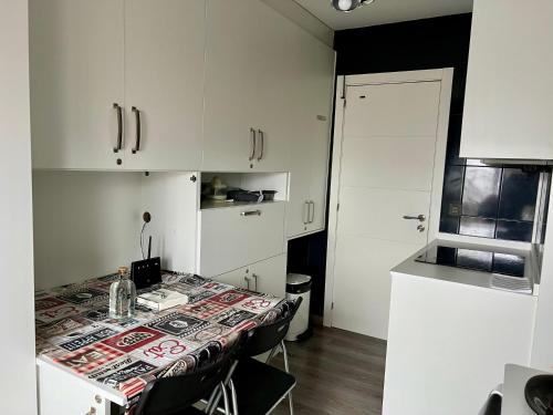 a kitchen with a table with chairs and white cabinets at El Marquesado de Santiago en Milladoiro in Amés