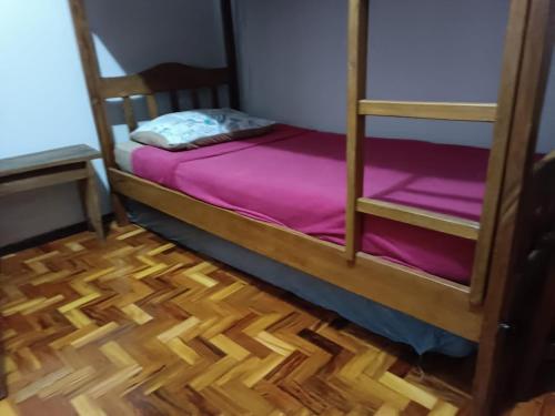 a bedroom with two bunk beds and a wooden floor at Hostel do Papai 3 in Lavras