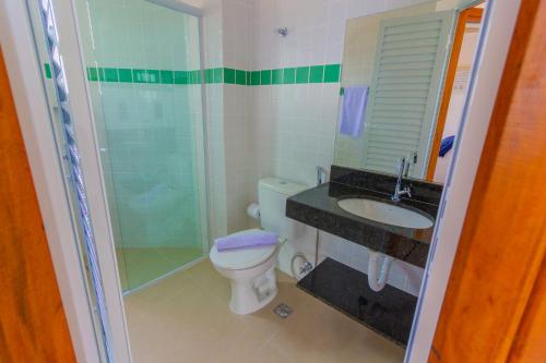 a bathroom with a toilet and a shower and a sink at Pousada Assojuris in Caraguatatuba
