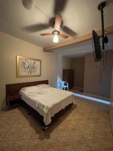 a bedroom with a bed and a ceiling fan at Hotel Flor D Liz in Goiânia