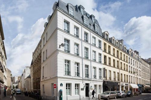 a large white building on a city street at Les Tournelles in Paris