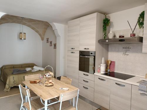 cocina pequeña con mesa y cama en History HOUSE, en Fasano