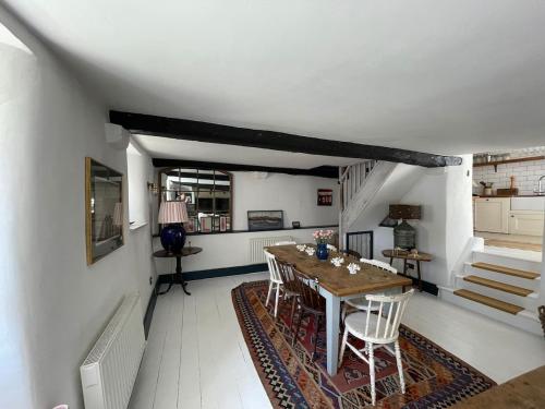 a dining room with a wooden table and chairs at Buckley Cottage, Batson Salcombe in Salcombe