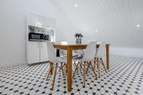 a kitchen with a wooden table and white chairs at Modern Lofts in Plaza De La Independencia in Panama City