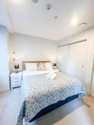 a bedroom with a large bed in a room at Stylish 2BR City Retreat with Cityscape Views, Pool & Gym in Auckland