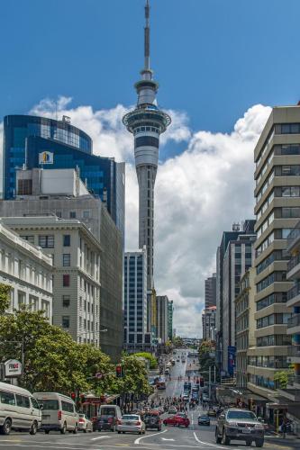 a busy city street with cars and a tower at Stylish 2BR City Retreat with Cityscape Views, Pool & Gym in Auckland
