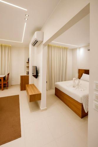 a white bedroom with a bed and a table at Diva Suites in Hurghada