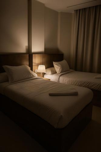two beds in a dark room with a lamp at Diva Suites in Hurghada