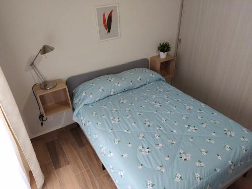 ein kleines Schlafzimmer mit einem Bett mit einer blauen Bettdecke in der Unterkunft Departamento en Centro Histórico, Ciudad de Mexico in Mexiko-Stadt