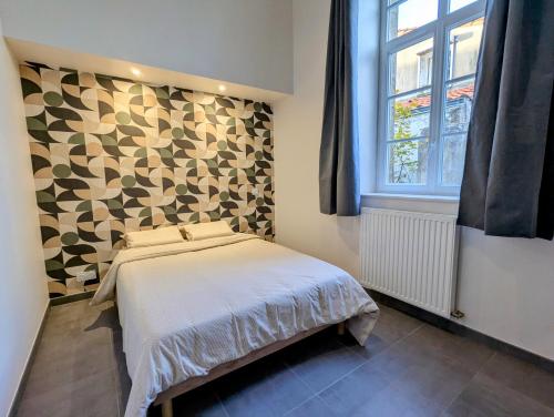 a small bedroom with a bed and a window at La Bonne Ecole in Les Landes-Génusson