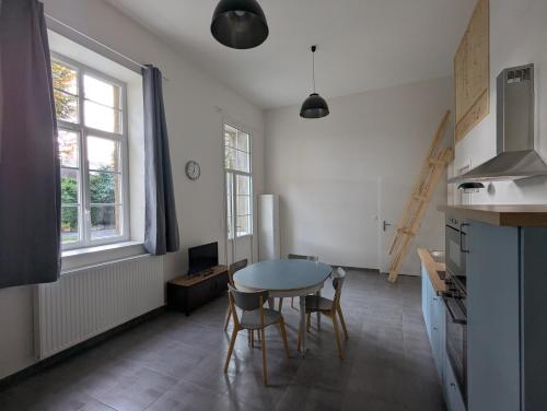 a kitchen with a table and chairs in a room at La Bonne Ecole in Les Landes-Génusson