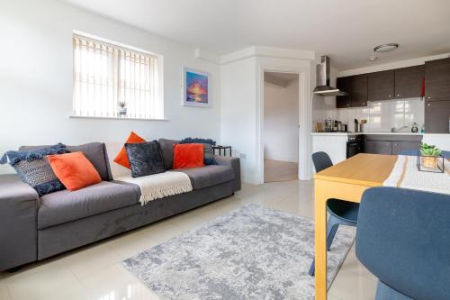 a living room with a couch and a table at Lovely 2 Bedroom 2 Bathroom Apartment with Parking in Loughborough