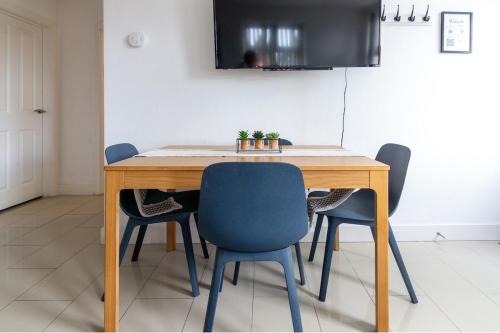 a dining room table with four chairs and a television at Lovely 2 Bedroom 2 Bathroom Apartment with Parking in Loughborough