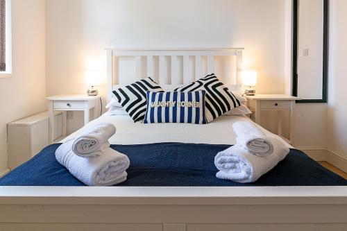 a white bed with towels on top of it at Lovely 2 Bedroom 2 Bathroom Apartment with Parking in Loughborough