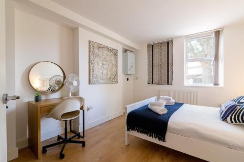 a bedroom with a bed and a desk and a mirror at Lovely 2 Bedroom 2 Bathroom Apartment with Parking in Loughborough