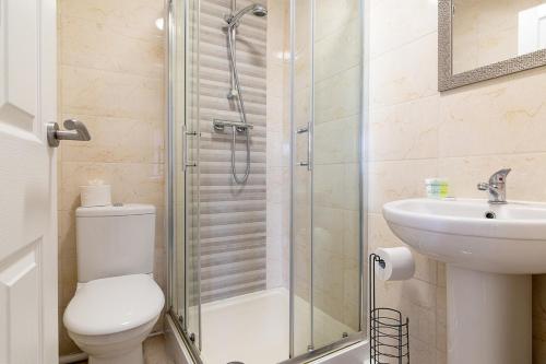 a bathroom with a shower and a toilet and a sink at Lovely 2 Bedroom 2 Bathroom Apartment with Parking in Loughborough