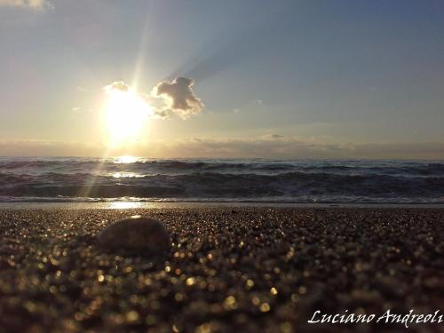 a sunset on a beach with the ocean at Sea Garden Hotel in Acquappesa