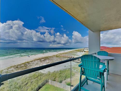 a balcony with a table and chairs and the beach at Regency Towers #505 West in Oriole Beach