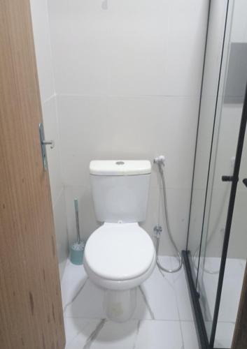 a white bathroom with a toilet and a shower at Espaço familiar 2 in Vila Velha