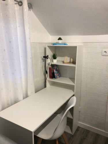 a room with a desk and a table with a chair at Casa refúgio 