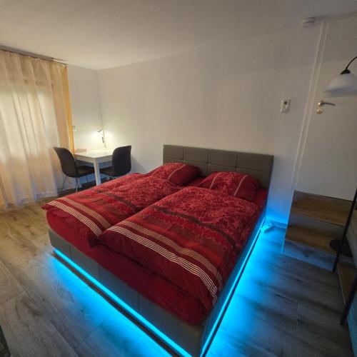 a bedroom with a red bed with a blue light at Gemütliches und komfortables Studio in Frankfurt in Frankfurt