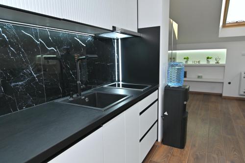a kitchen with a sink and a black counter top at Lux&Spa Petko in Pirot