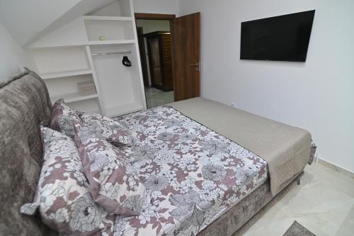 a bedroom with a bed with a flowered blanket at Lux&Spa Petko in Pirot