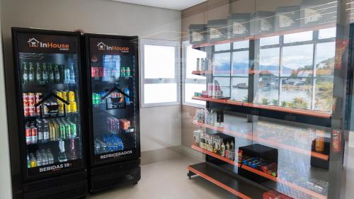 a store with two refrigerators and bottles of alcohol at Pousada Assojuris in Caraguatatuba