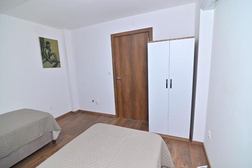 a bedroom with two beds and a wooden door at Lux&Spa Petko in Pirot