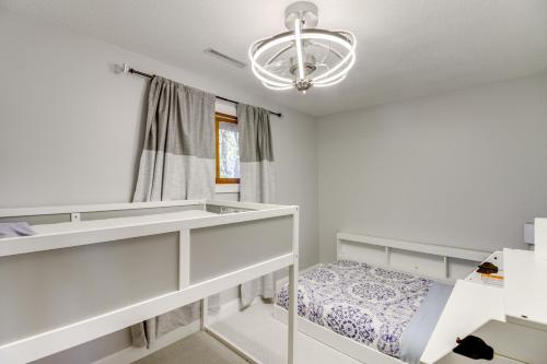 a white bedroom with a bed and a chandelier at Lakefront Home on 17 Acres 9 Mi to Dtwn Brainerd! in East Gull Lake