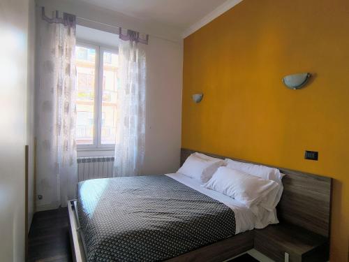 a bedroom with a bed with a yellow wall at Domus Oleandri - WelcomeToRhome in Rome