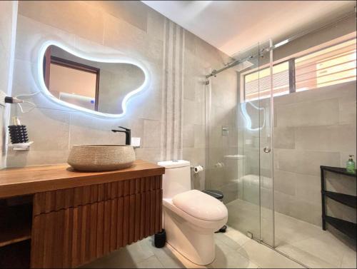 a bathroom with a toilet and a glass shower at Casa Equipada cerca Hotel Oro Verde Cuenca in Cuenca
