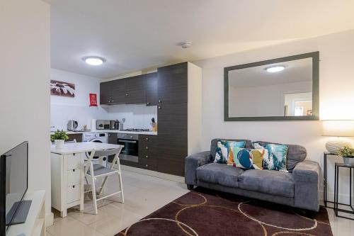 a living room with a couch and a kitchen at 2 bedroom Large Town Centre Apartment FREE Parking in Loughborough