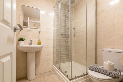 a bathroom with a shower and a toilet and a sink at 2 bedroom Large Town Centre Apartment FREE Parking in Loughborough